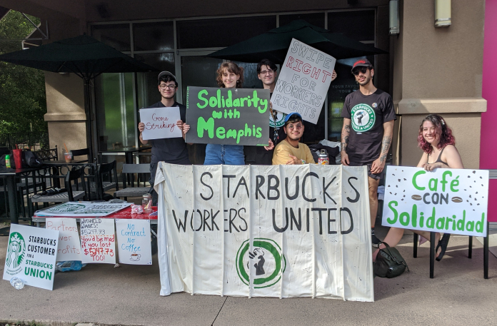 A group of people standing in front of a sign