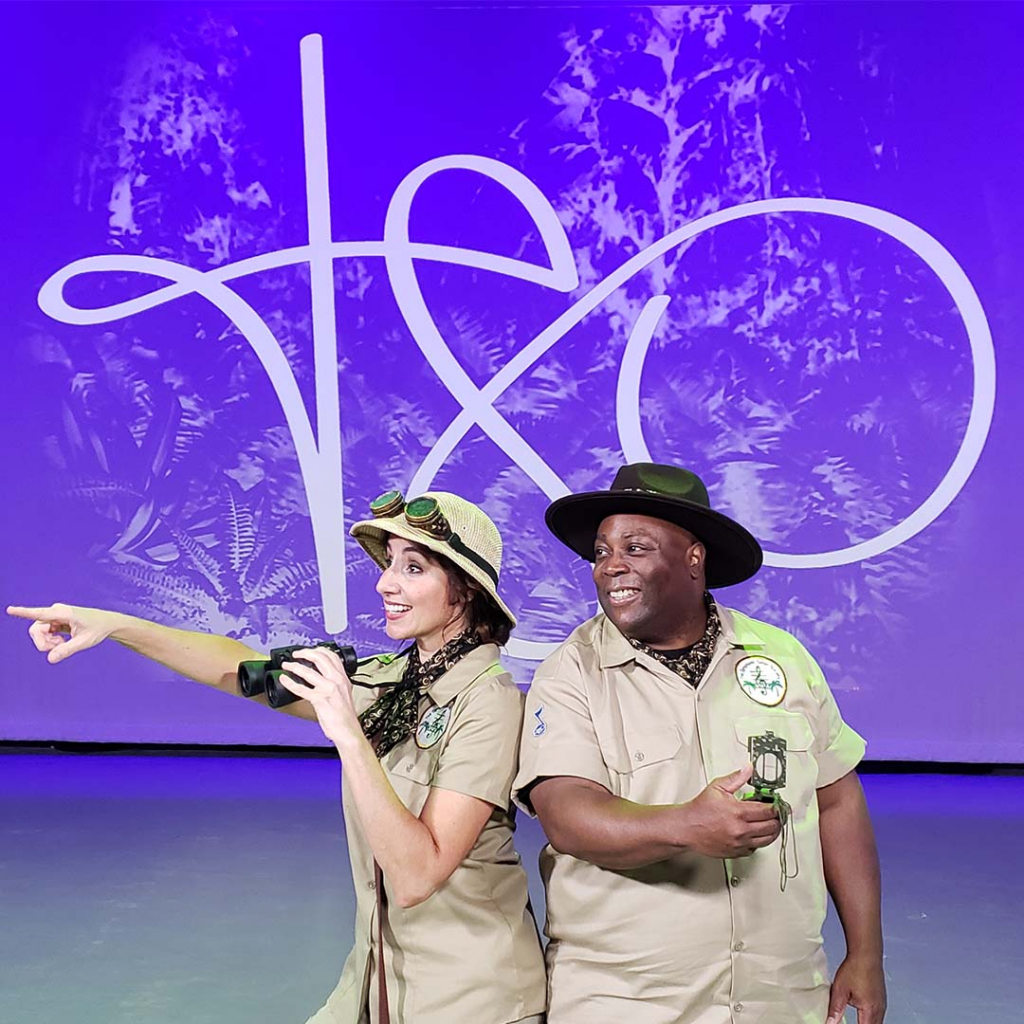 A woman and man standing on a stage posing for the camera