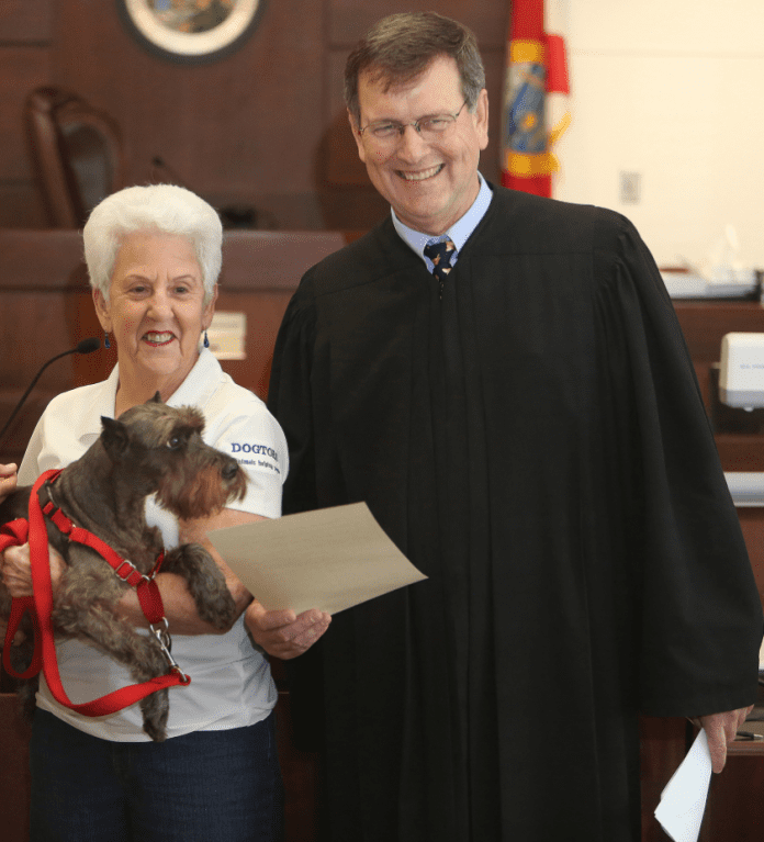 A person holding a dog posing for the camera