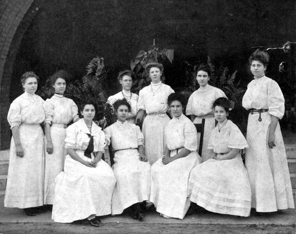 A  photo of a group of ten women in white.