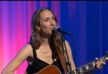 Tribute to beloved singer and creator of the Local Routes theme song A woman sitting on a stage in front of a curtain