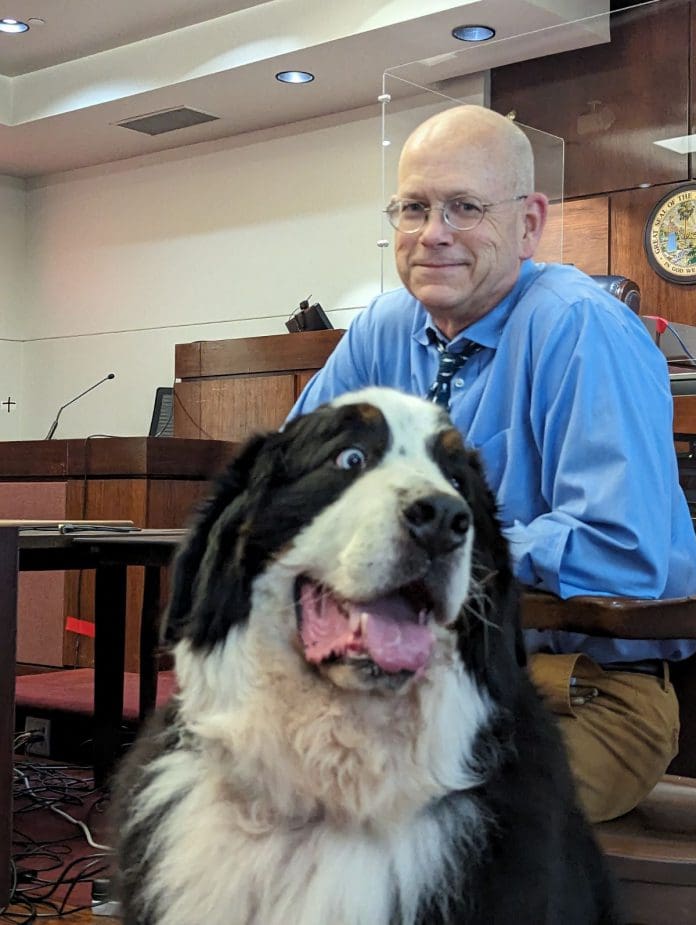 A man and a dog posing for the camera