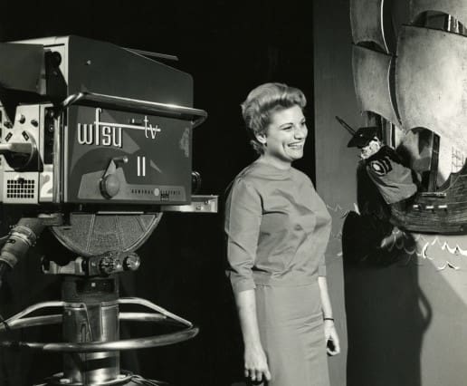 A woman standing next to a TV camera that says WFSU TV