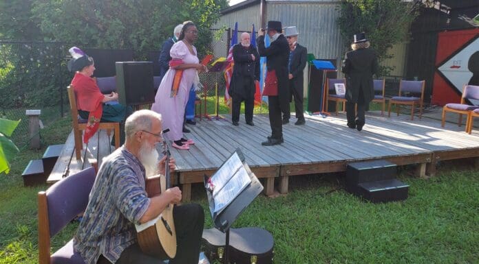 Theater With A Birthday Mission A group of people sitting at a picnic table