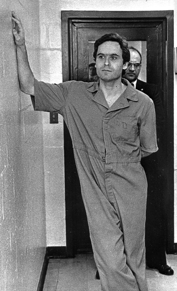 Ted Bundy standing in front of a door