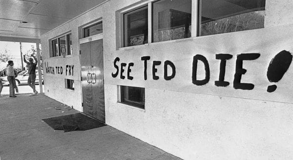Homemade signs on wall sayng "Watch Ted Fry" and " See Ted Die!"