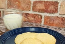 Recipes from Our Local Routes | Mary Archer’s Tea Cakes three cookies on a blue plate next to a glass of milk