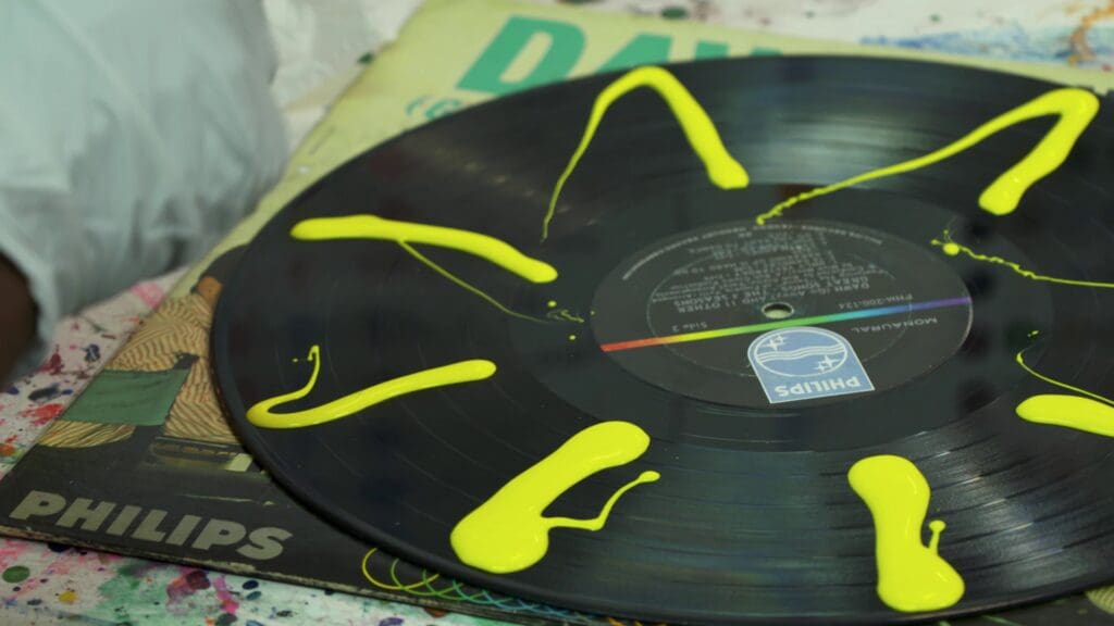 yellow paint poured onto a black record