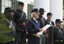 Why people in Florida celebrate May 20th AND June 19th as Emancipation Days A group of people in Union civil war uniforms. Man in center is reading off piece of paper.