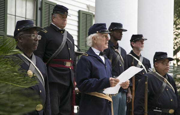 Why people in Florida celebrate May 20th AND June 19th as Emancipation Days A group of people in Union civil war uniforms. Man in center is reading off piece of paper.