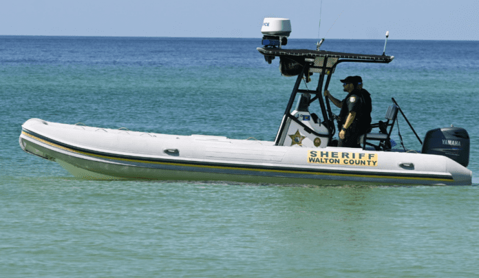 A man riding on the back of a boat in a body of water