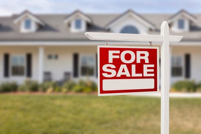 A close up of a sign in front of a house