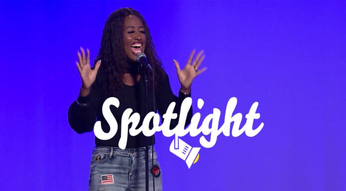 Spotlight Woman singing in front of blue background.