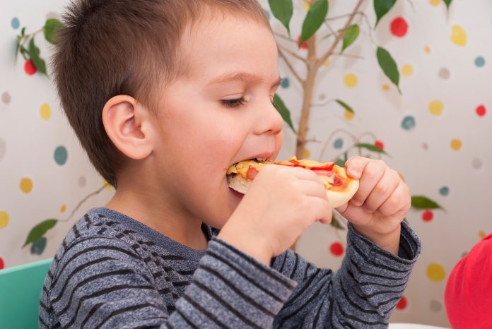 A little boy that is eating some food