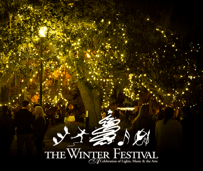 A group of people performing on stage in front of a tree