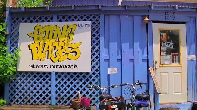 Helping Homeless Teens Find Hope Purple cottage with yellow graffiti text outside