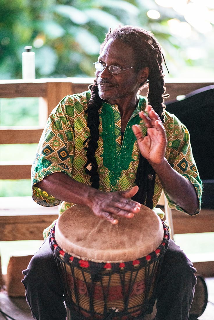 man with dreads playing drums