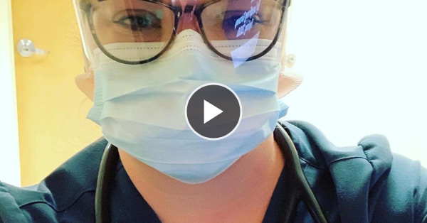 womman in scrubs and mask selfie with play button