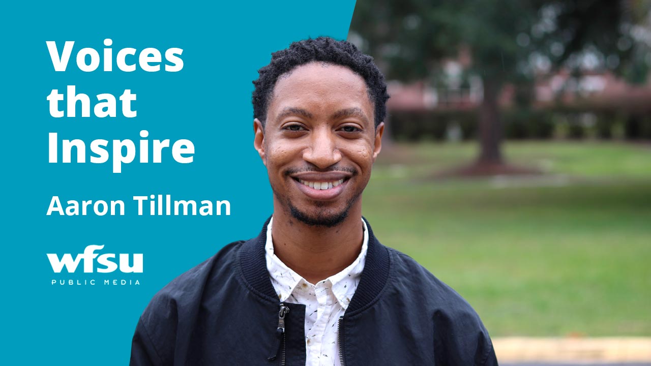 A smiling man in a dark jacket stands outside.