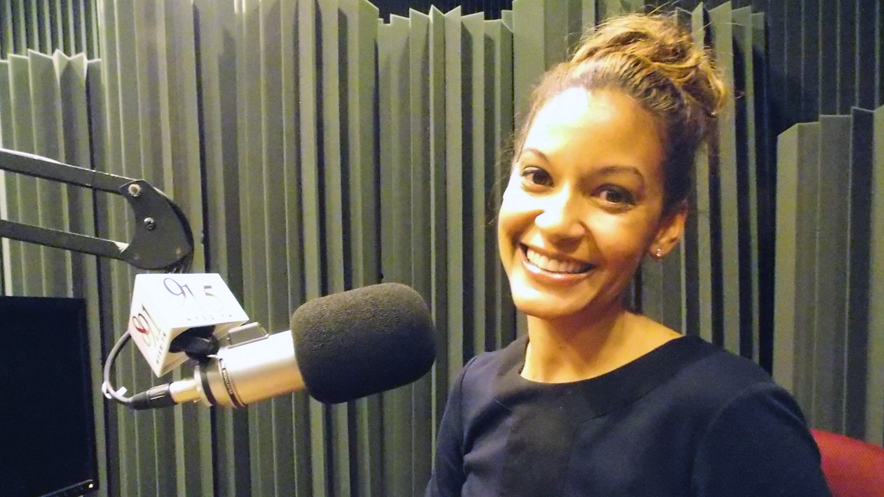 Audra Pittman sitting in WFSU's radio studio in front of the mic