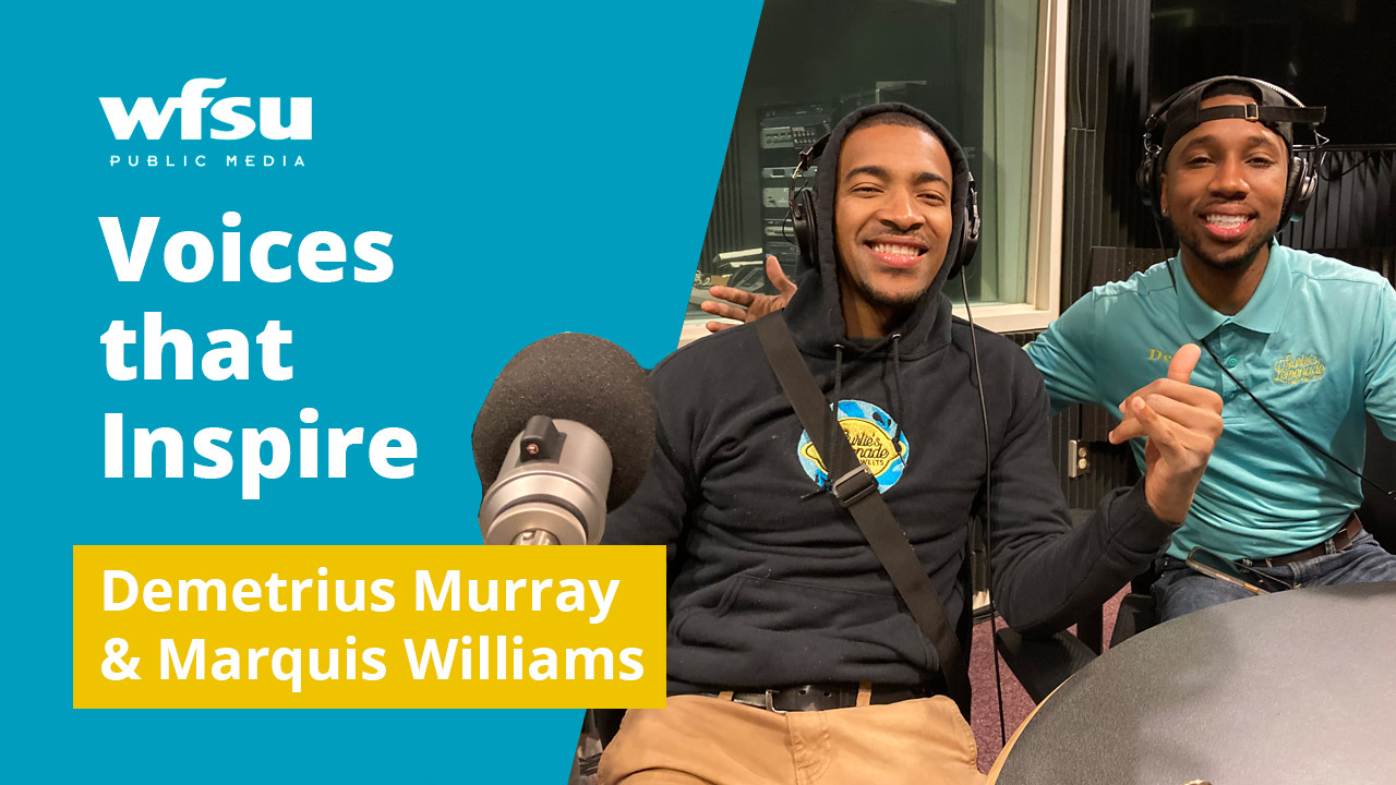 Two smiling men sit facing forward.