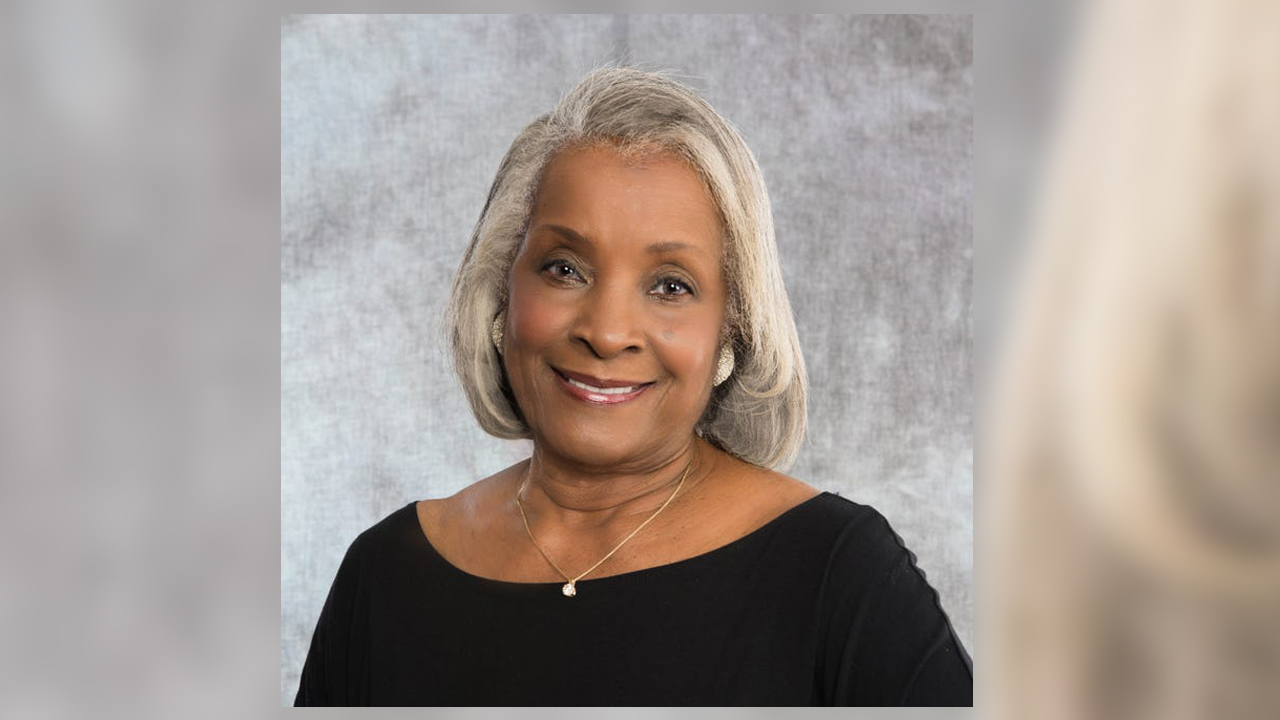 woman smiling in front of gray background