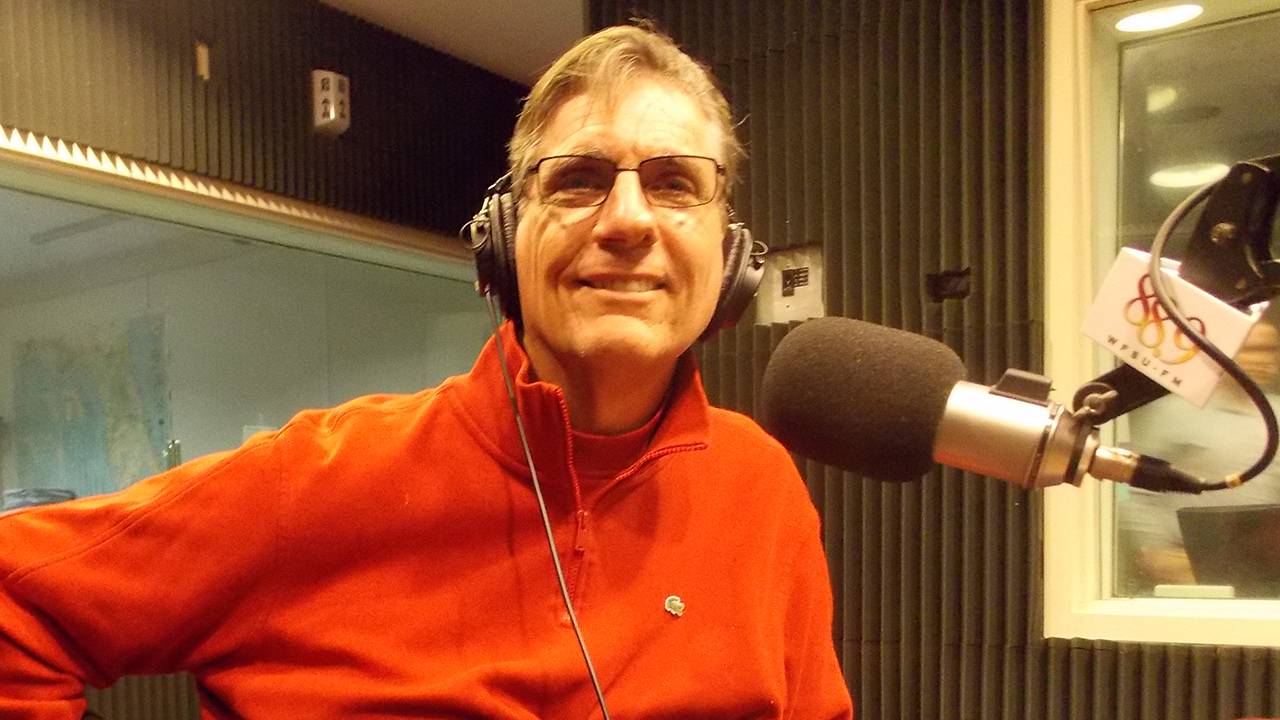 J. R. Harding sitting in WFSU's radio studio in front of the mic