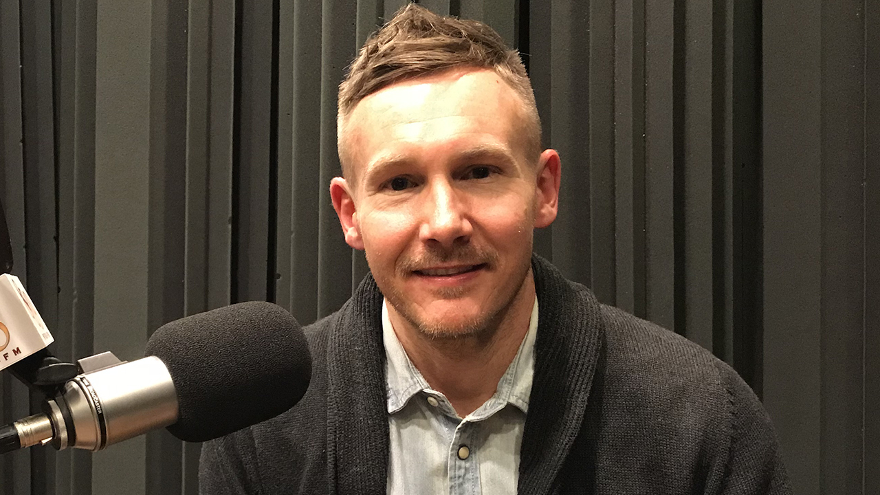 Jake at WFSU sitting in front of a microphone