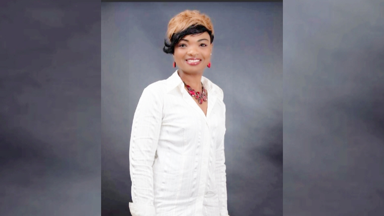 Woman smiling in front of a grey background