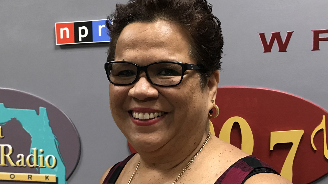 Luci, wearing glasses, smiling and looking at camera