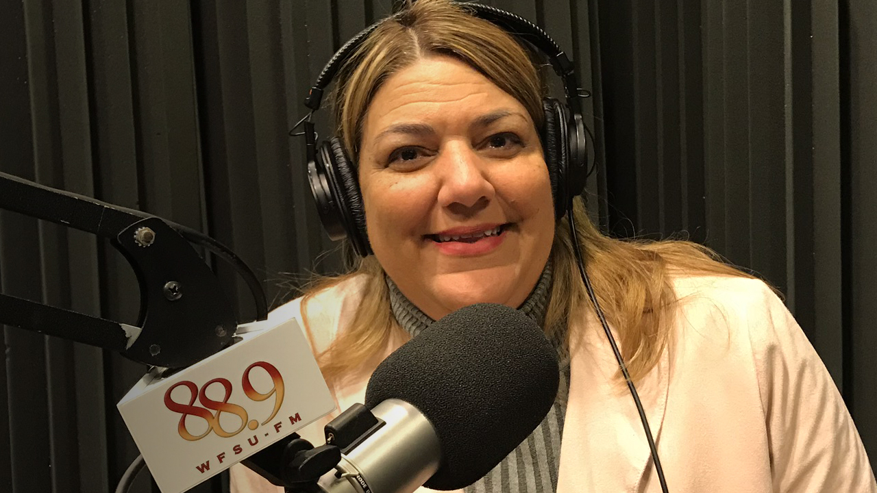 Madeline Pumariega sitting in WFSU's radio studio in front of the mic