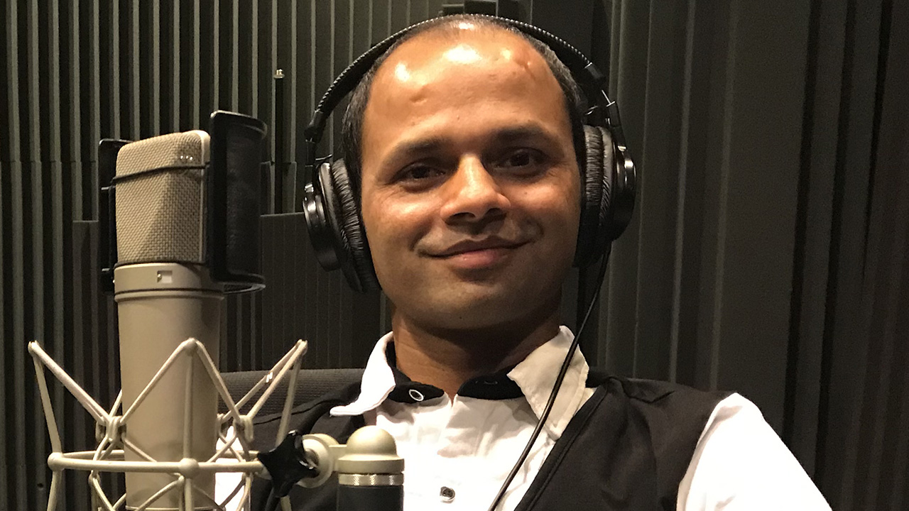 headshot of Madhu wearing headphones in the WFSU studio
