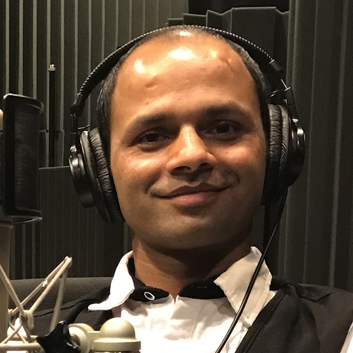 headshot of Madhu wearing headphones in the WFSU studio