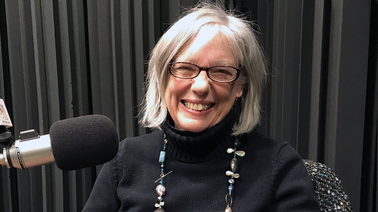 Meg Baldwin sitting in WFSU's radio studio in front of the mic