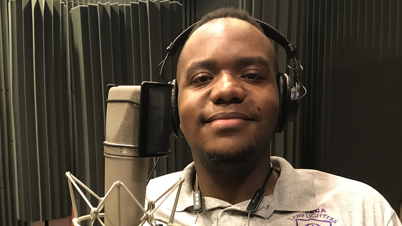 Quan at WFSU next to microphone