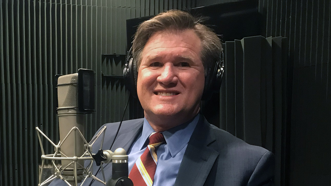 Rick with headphones in front of mic in the studio