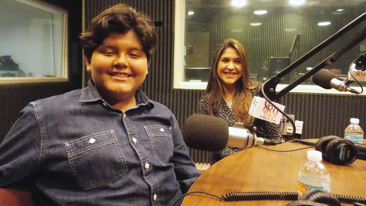 Veronica and Gabrielle Rios sitting in WFSU's radio studio in front of the mic