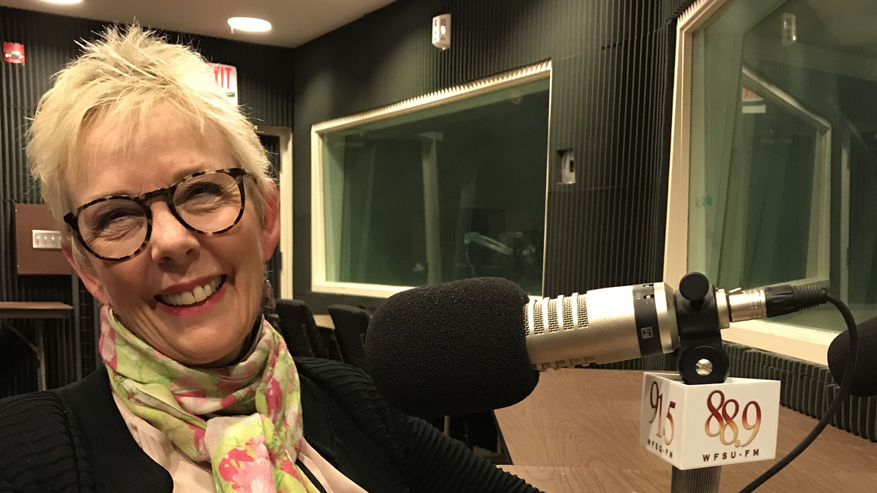 Susan Fiorito smiling in front of the microphone
