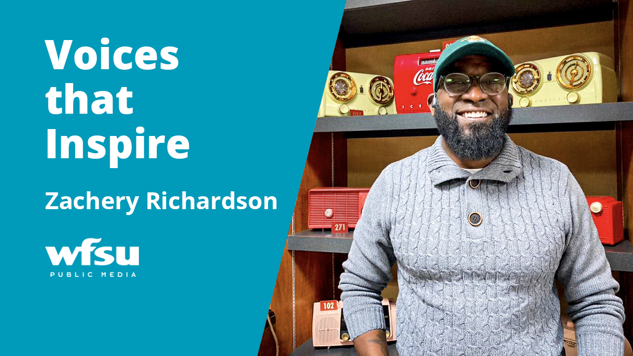 A smiling man stand in front of a radio collection.