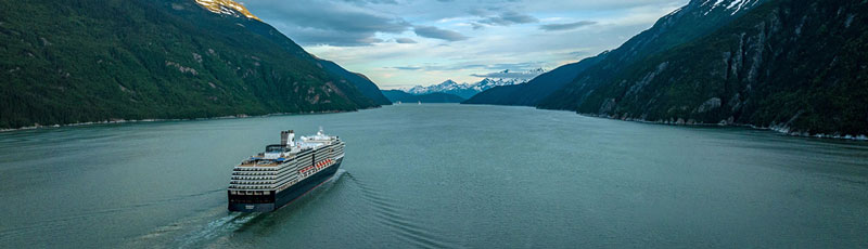 cruise ship in the ocean with mountains in the distance