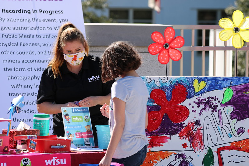 woman and girl standing next to craft table at event