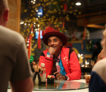 man sitting at a table wearing a red coat and hat