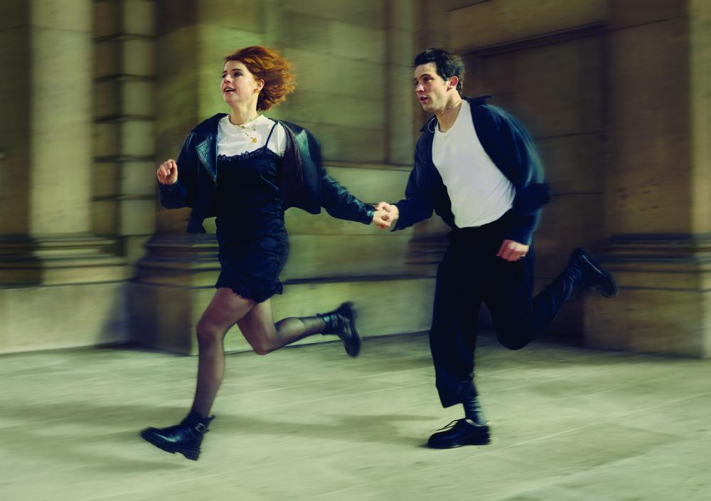 A man and woman running inside a hall