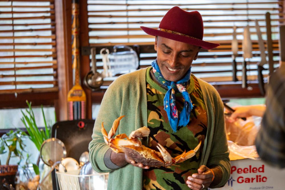 A person in a red hat holding a crab