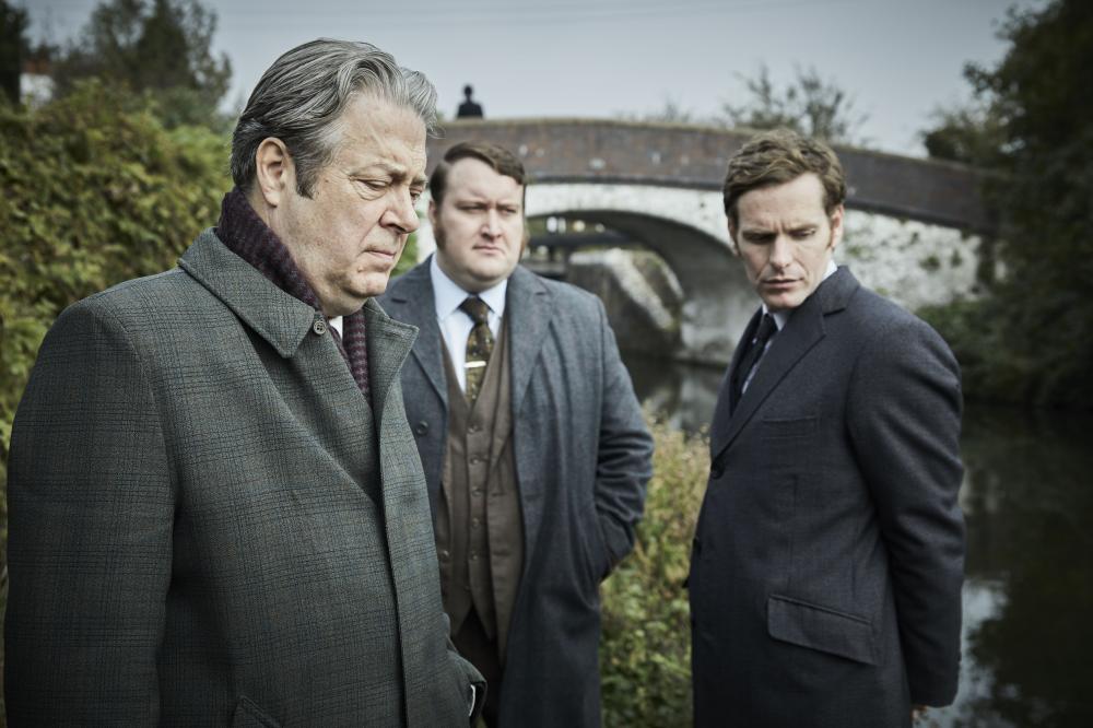 3 men in suits looking in disdain at the ground