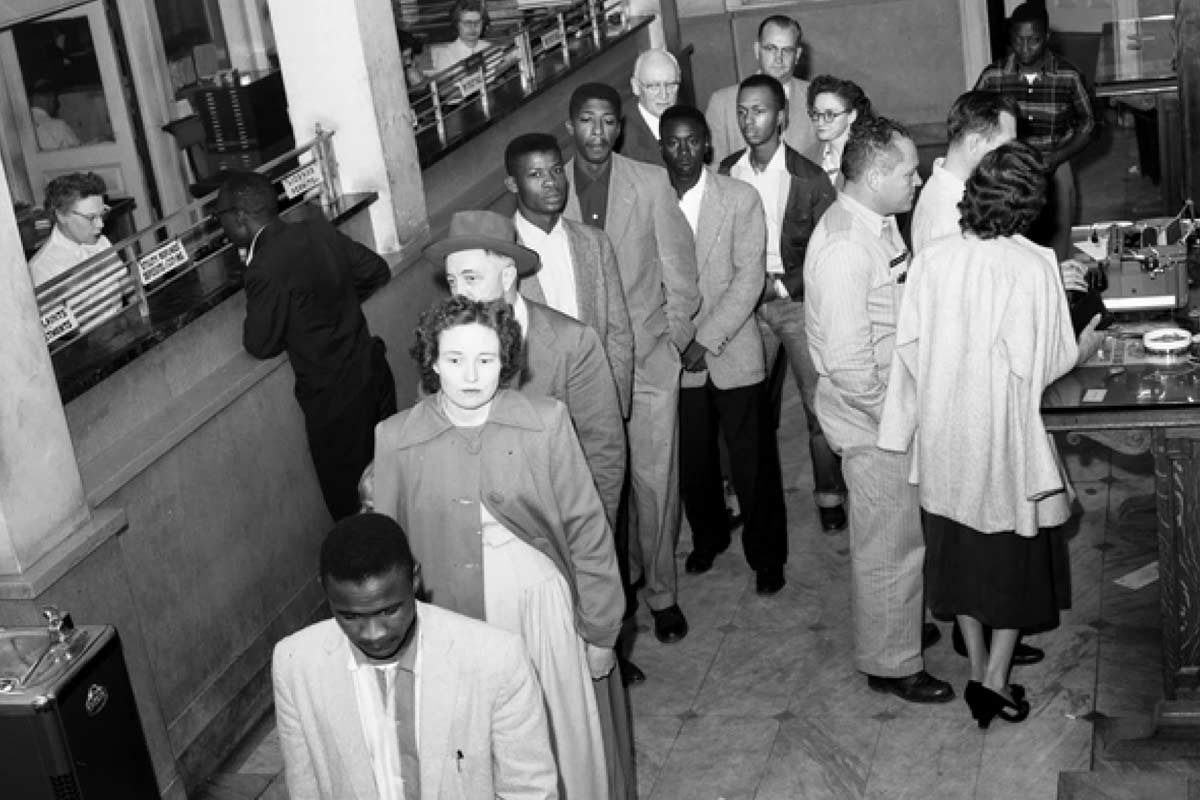 mid-century photo people standing in line inside government building